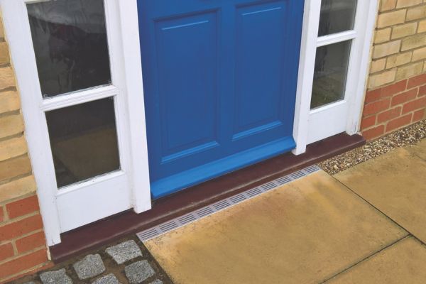 ACO Threshold Drain with a Silver Aluminum grating at a doorway entrance
